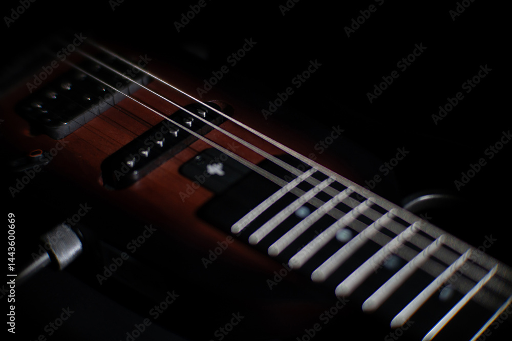 Fototapeta premium Close-up view of a dark electric guitar, with focus on the neck featuring frets and fret markers Glossy finish, blackbrown color scheme, metallic strings Realistic photographic style, no additiona