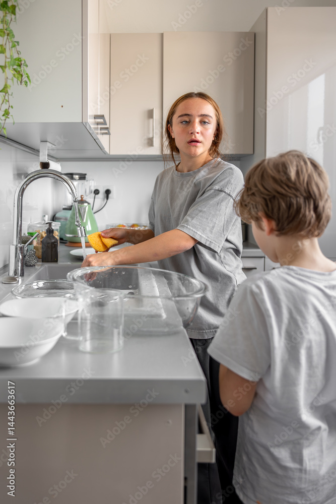 Teenage girl washing dishes. Washing dishes in the kitchen. Housework. Teenage girl washing dishes. Washing dishes in the kitchen. Housework.