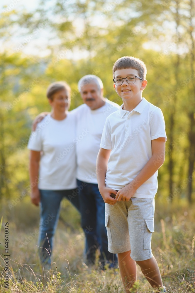 Fototapeta premium Grandfather grandmother and grandson having fun outdoors in park