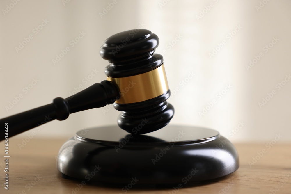 Judge's gavel on wooden table against light background, closeup Judge's gavel on wooden table against light background, closeup