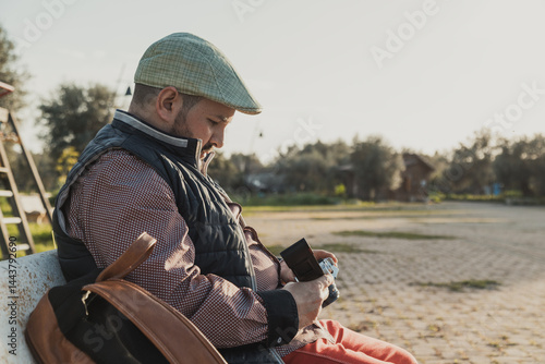 Photographer Taking A Rest At The Park Bench