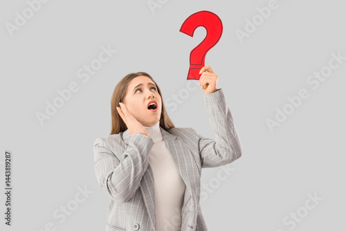Puzzled businesswoman holdi...
