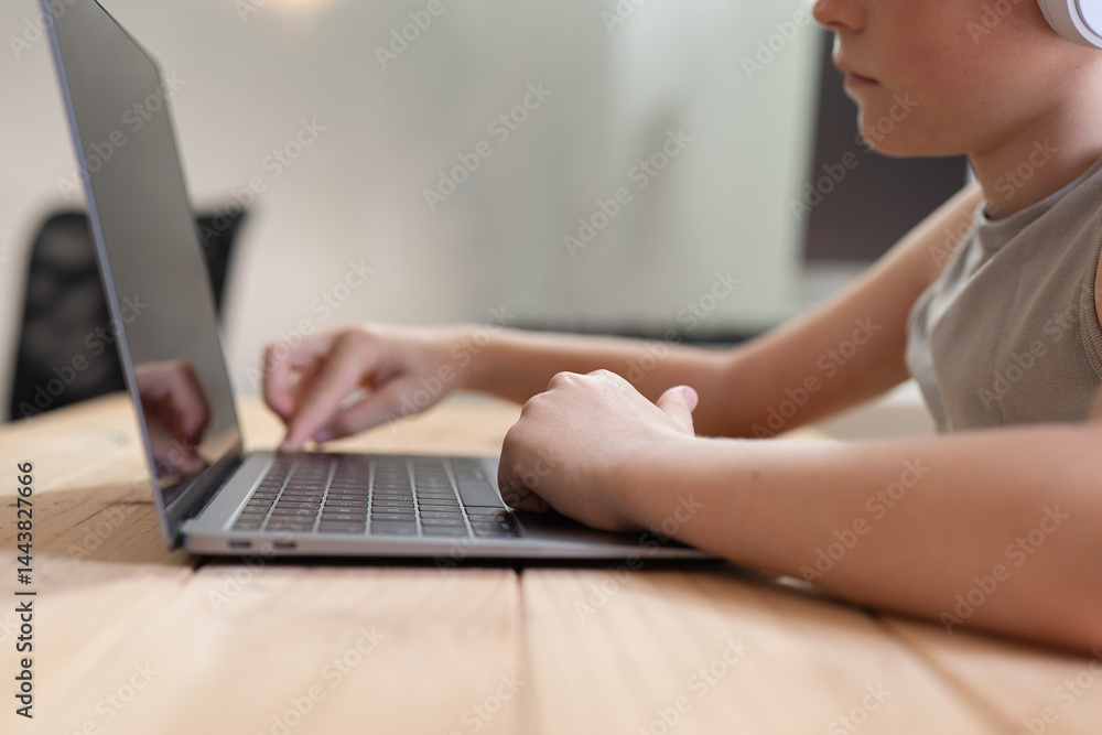 Young boy using laptop at home with focus on hand Young boy using laptop at home with focus on hand