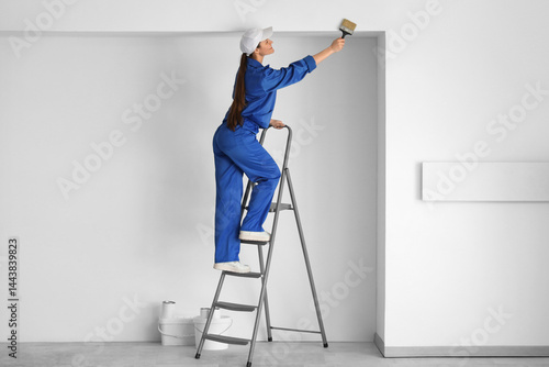 Obraz na płótnie Female worker with brush on stepladder painting wall in room w salonie
