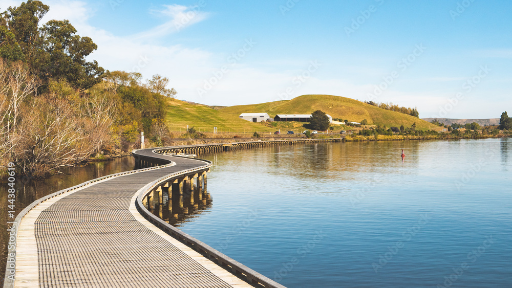Obraz premium Boardwalk along the lake waihola new zealand beautiful landscape scenery wooden bridge 