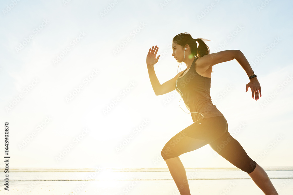 Obraz premium Woman, running and fast at beach with earphones, training and listening to music with mock up space at sunrise. Girl, person and speed with streaming, subscription and fitness with workout in Spain