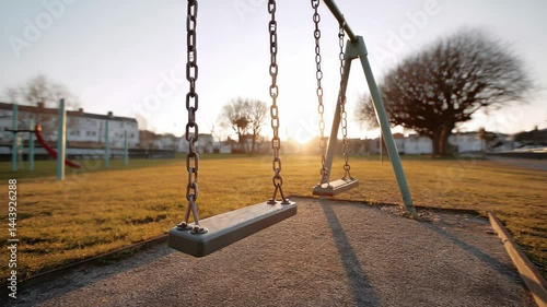 Swing Set in Empty Playground at Sunset with Warm Glow