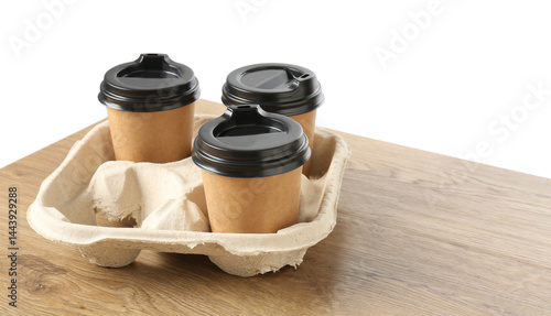 Paper coffee cups in cardboard holder on wooden table. Space for text