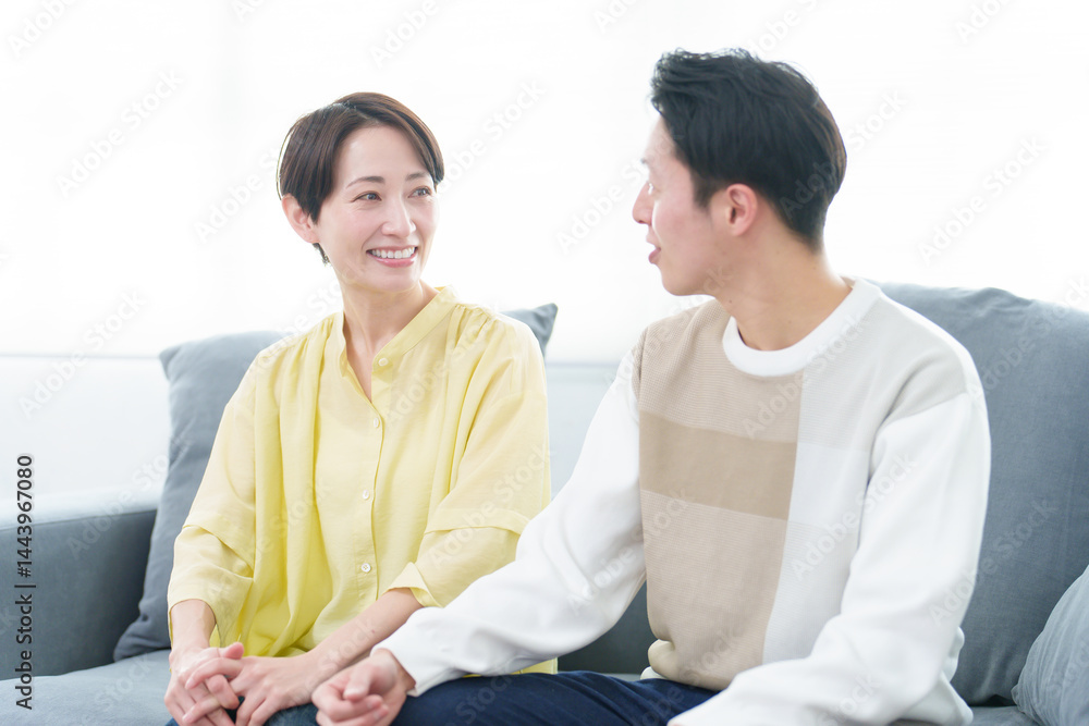 リビングで雑談をする若い夫婦