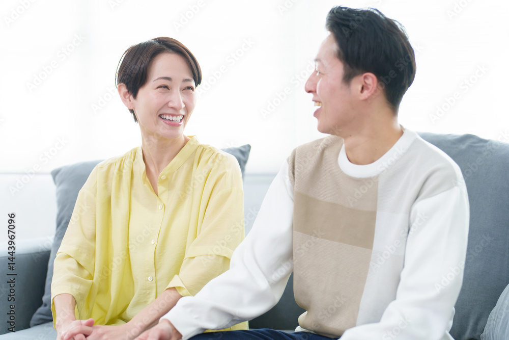 リビングで雑談をする若い夫婦
