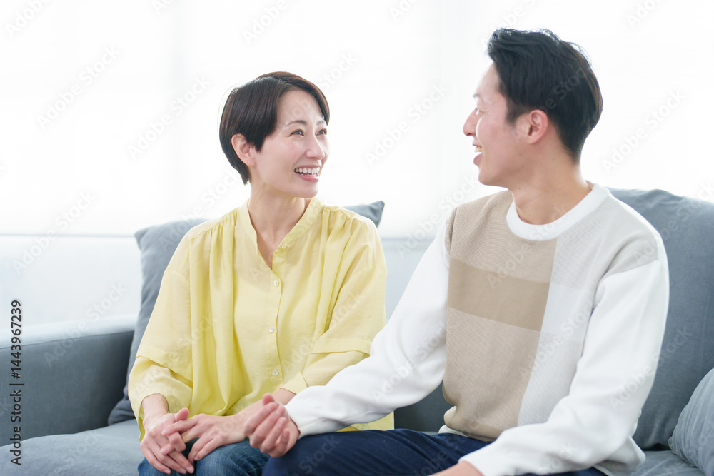 リビングで雑談をする若い夫婦