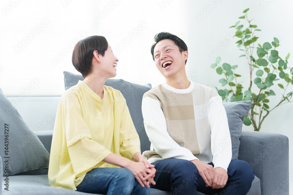 リビングで雑談をする若い夫婦
