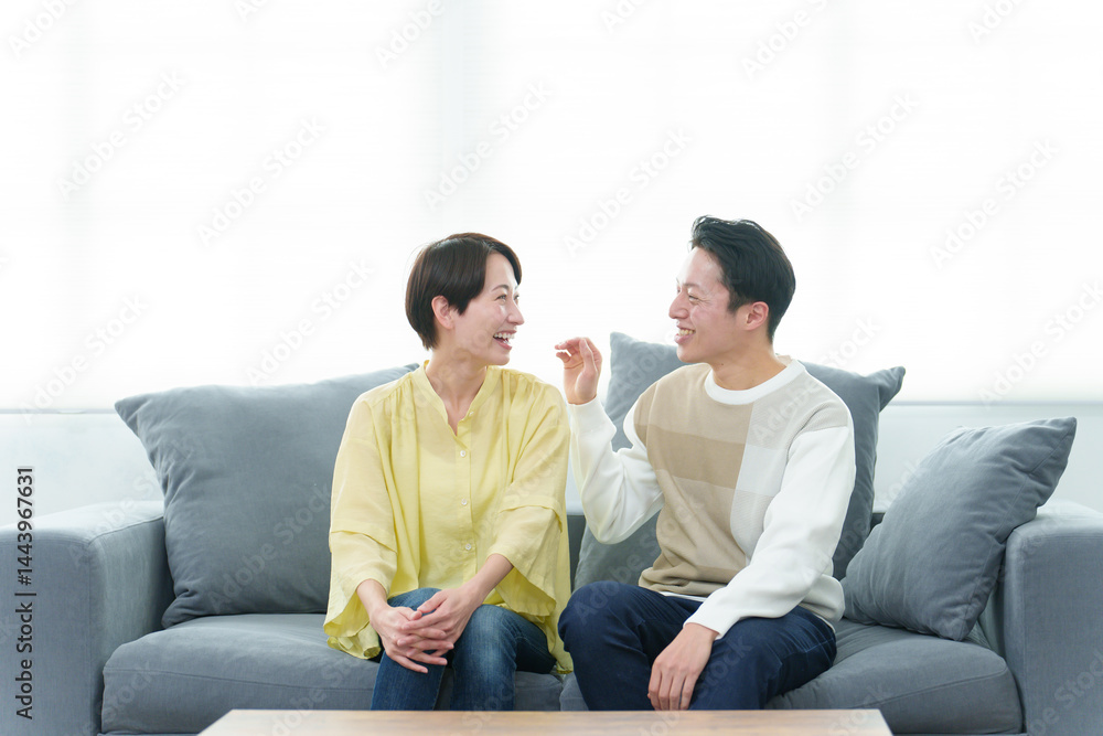 リビングで雑談をする若い夫婦