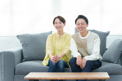 リビングでテレビを見る若い夫婦