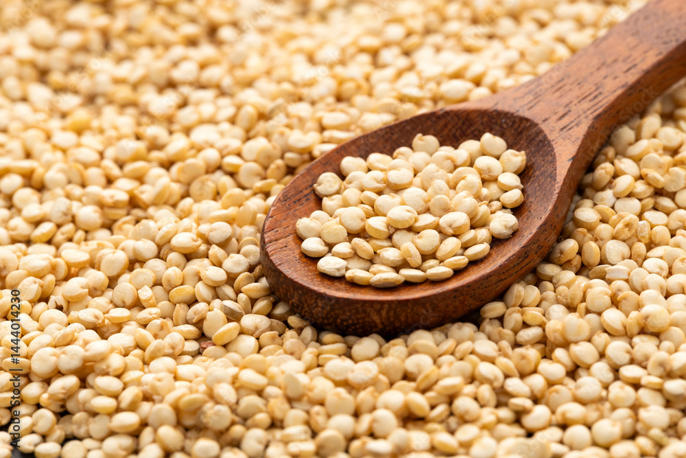 Fototapeta premium Organic white quinoa seeds in a wooden spoon - Chenopodium quinoa