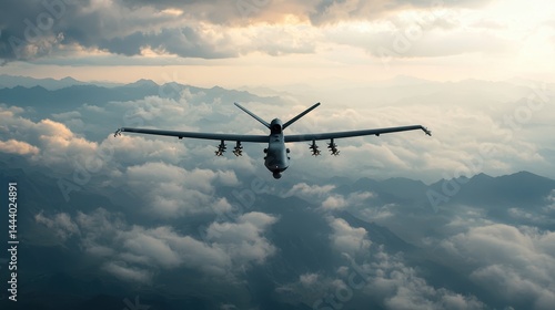 Aerial View of Military Drone Flying Above Cloudy Landscape During Sunset with Mountains in Background