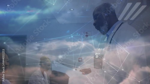 Medical team reviewing patient paperwork in clinic, with floating digital cloud network graphics
