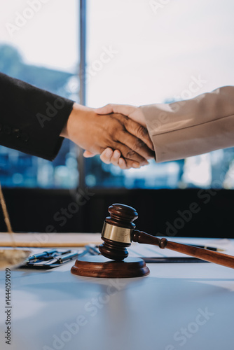 Wallpaper Mural Two businesspeople are shaking hands in a law office with a scale and a gavel on the table. Torontodigital.ca