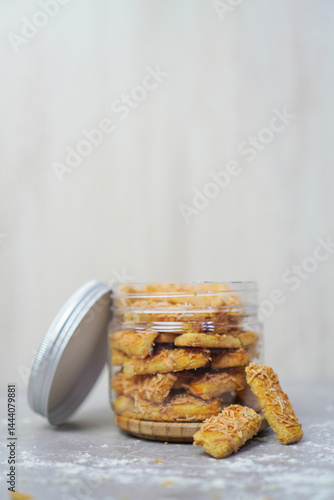 an open jar filled with cheese cookies and some cookies outside