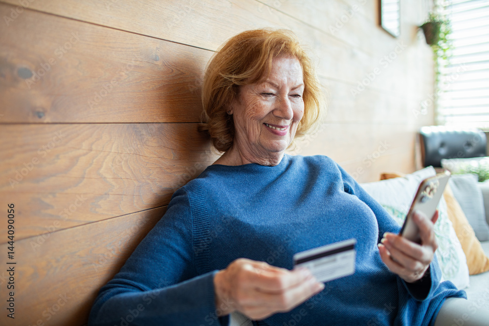 Senior woman shopping online with credit card and smartphone at home