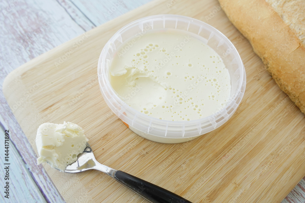Creamy spread on a wooden board next to fresh bread Creamy spread on a wooden board next to fresh bread
