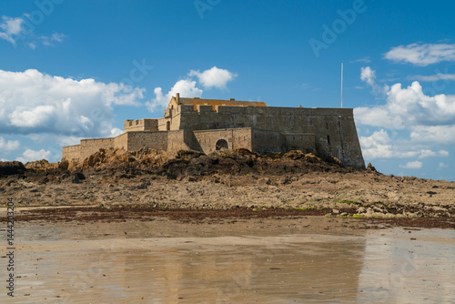 View of the Petit Be Fort on a small island and the exposed ocean floor at low tide on a sunny summer day, Saint-Malo, Brittany, France