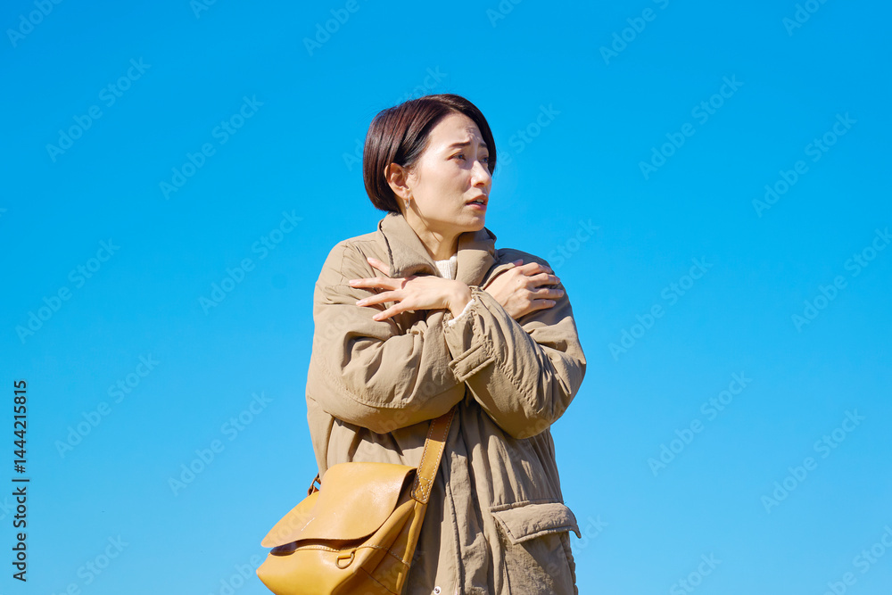 Fototapeta premium 外で凍えるミドルエイジの女性