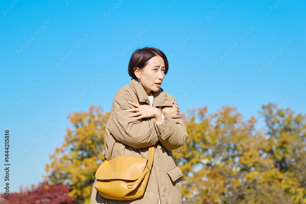 Fototapeta premium 外で凍えるミドルエイジの女性