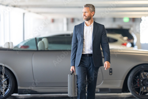 Rich business man on expensive luxury car. Rich businessman in suit outdoors. Successful rich businessman in city. Businessman with a confident look. Success business. Businessman walk on street.