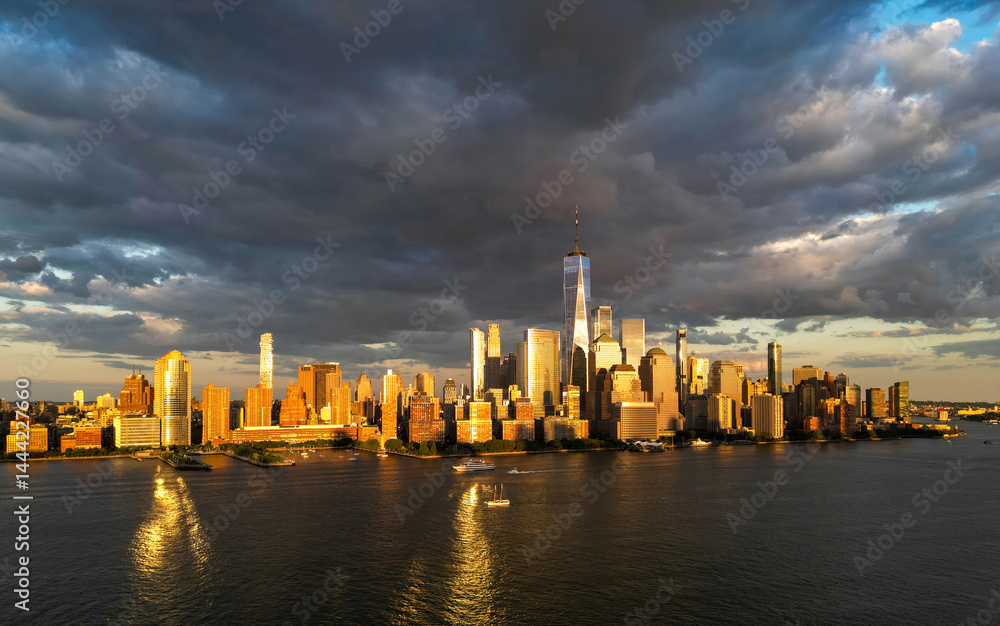 Manhattan aerial skyline, New York. Panorama view of New York city skyscrapers on dramatic sky. USA NYC. Lower NYC skyline on sunset. New York cityscape. New York City with clouds from drone.