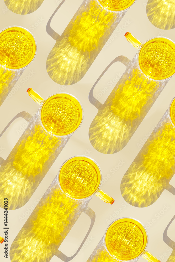 Vibrant yellow glass cups on beige background, casting artistic light reflections and shadows in natural sunlight. Summer drink concept, minimal trend pattern of transparent glasses, monochrome
