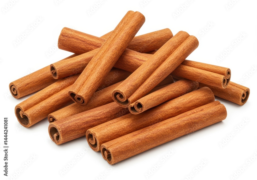 A pile of cinnamon sticks arranged randomly on a white surface showing their color and rolled texture A pile of cinnamon sticks arranged randomly on a white surface showing their color and rolled texture