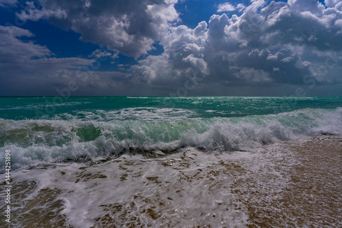 Summer beach scene. Tropical beach coastline. Exotic beach destination. Foamy beach waves. Sunny holiday.