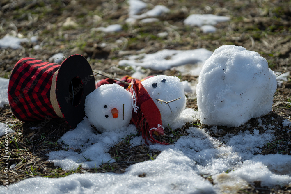 Melted snowman as a symbol of warm winter spring. Winter and spring seasons change. Melting snowman with puddles around it. From winter to spring. Melting snowman in warm weather.