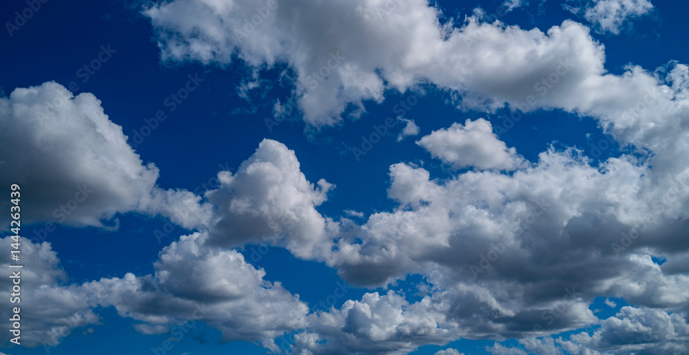 Background with clouds on blue sky. Sky view. Beautiful sunny sky. Clouds on blue sky. Sun shining through the puffy clouds.