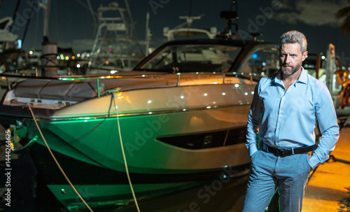 Obraz na płótnie Rich businessman near yacht. Wealthy businessman enjoying luxury lifestyle. Businessman on a private yacht. Financial freedom. Expensive yacht with a rich businessman. VIP premium elite concept. w salonie