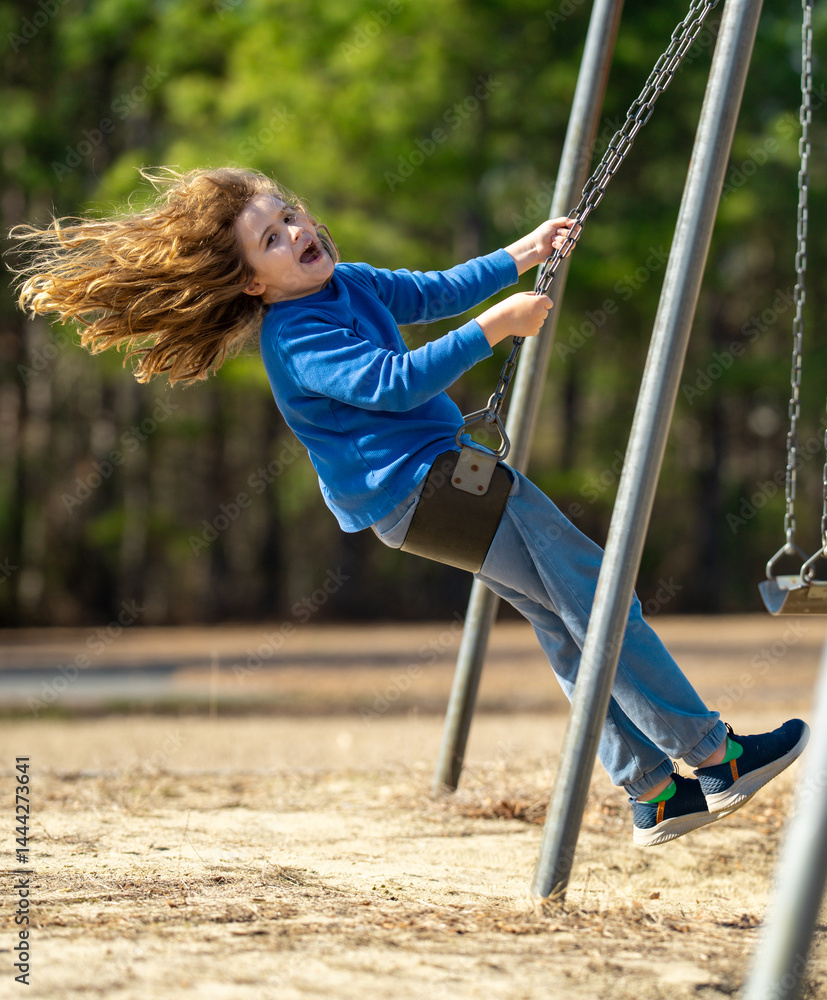 Excited child enjoying a fun ride. Happy kid on playground. Carefree child swinging in the air. Happy children play outside. Young boy swinging with excitement. Playful kid outdoor. Funny child face.