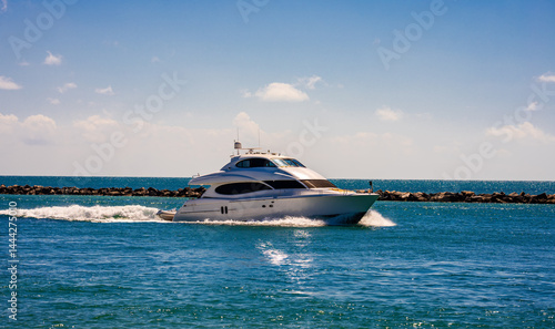 Yacht sailing on turquoise waters. Luxury superyacht at sea. Miami Beach with yachts. Tropical seascape with a sailboat. Cruise ship near the coastline. Sunset yacht voyage in Florida. Yacht in ocean.