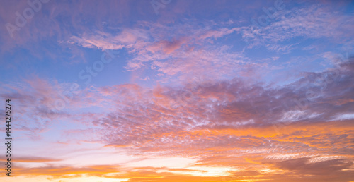 Obraz na płótnie Sky at sunset. Sunrise background. Sunset through clouds on sky. Twilight sky with sunset colors. Peaceful dawn with soft light. Dramatic dusk sunset with clouds. Sunshine in clear sky. w salonie