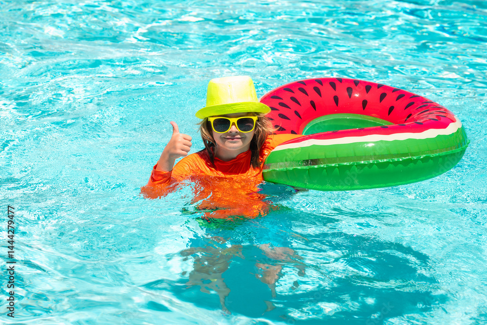 Summer kids vacation, boy swim in pool. Kid in swimming pool, relax swim on inflatable ring and has fun in water on summer vacation.