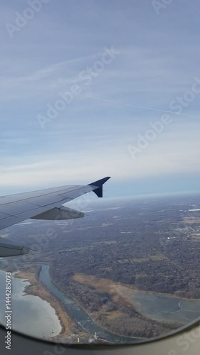 Vertical Shot of a Airplane Taking Off from a Runway and Climbing Over Landscape