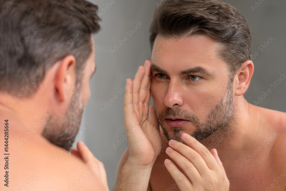 Fototapeta premium Caucasian beauty man use moisturizing face balm for healthy skin, male skincare concept. Male beauty and skin care portrait. Healthy clean face after shaving, facial treatment, skincare concept.