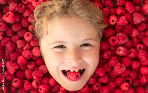 Obraz na płótnie The kids face with raspberries fruit and berries. Summer, pink red raspberry background. w salonie