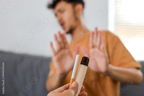Fotografía Hand holding out cigarette and vape, offering a man but he refuses
