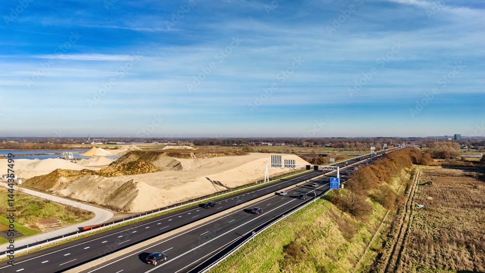 Industrial landscape with highway and cars traffic aerial drone view from above, modern motorway road in industrial zone, the Netherlands Industrial landscape with highway and cars traffic aerial drone view from above, modern motorway road in industrial zone, the Netherlands