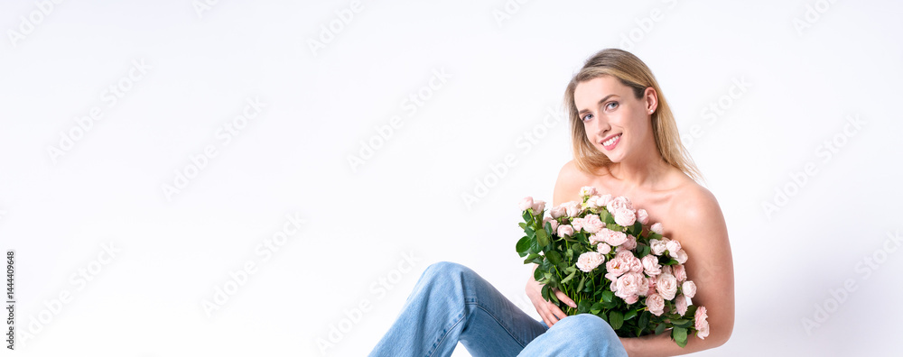 A modern girl with a luxurious bouquet of roses and in fashionable jeans, a stylish combination of natural beauty and current trends