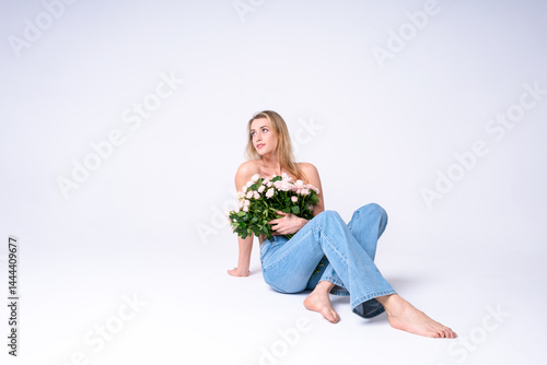 Light and airy shot of a young woman with a bouquet of roses on a white background, the embodiment of spring awakening and natural beauty