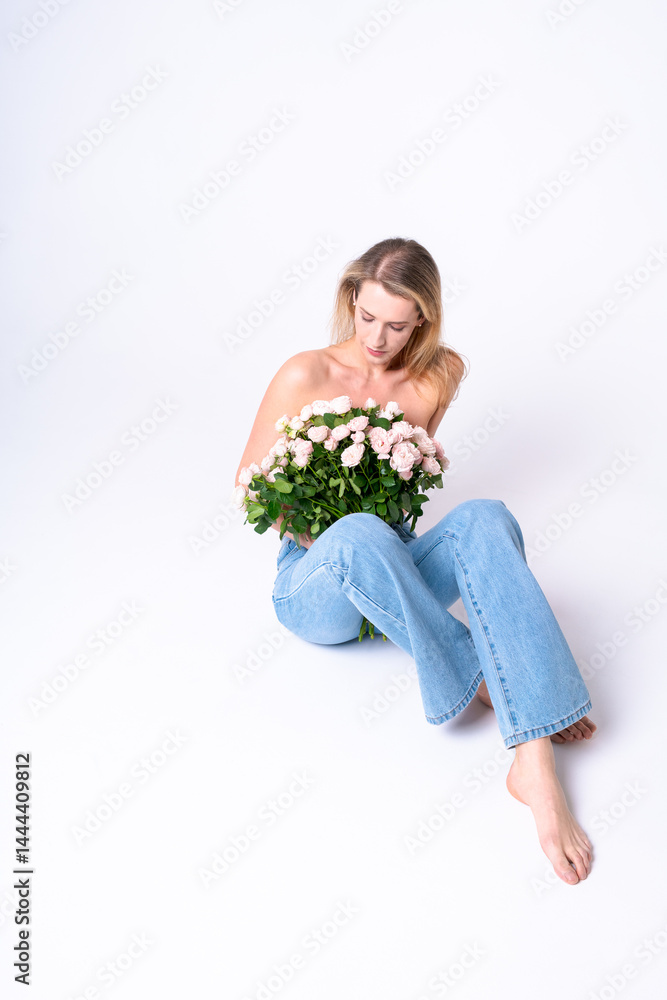 A young woman sits barefoot on the floor with a bouquet of roses, conveying the freshness, joy and spirit of spring in the frame