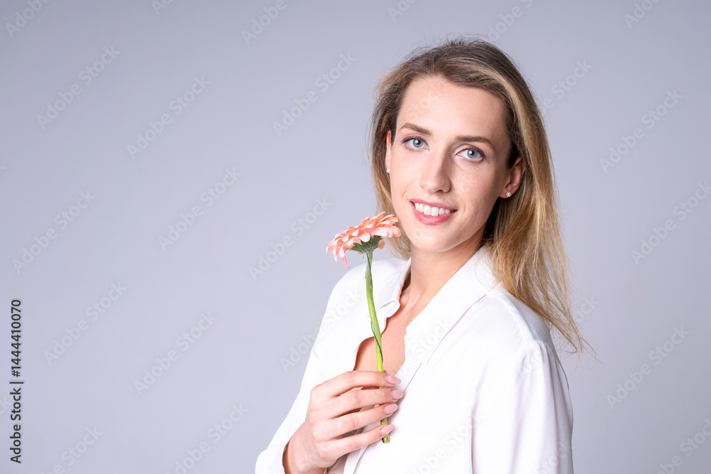 A woman holding a flower on a light background, ideal for advertising cosmetics, skin care or perfume