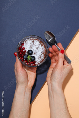 Obraz na płótnie Chocolate mousse with blueberries and pomegranate, on a peach background. w salonie